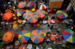 FILE PHOTO: Vendors sit under umbrellas inside a wholesale flower market in Bengaluru